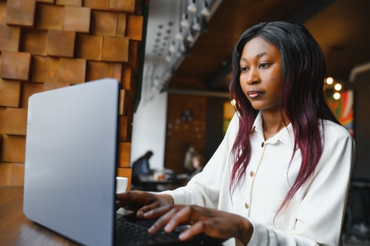 Focused young african american businesswoman or student looking at laptop, serious black woman working or studying with computer doing research or preparing for exam online photo