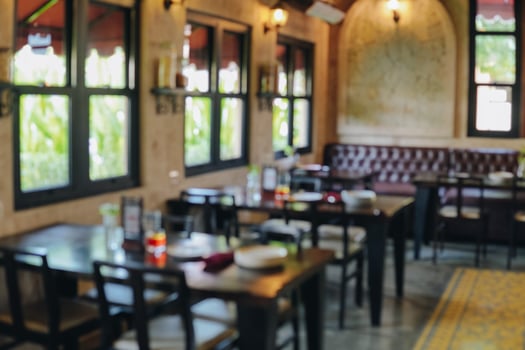 Interior portrait of a restaurant with a lot of tables and chairs. photo