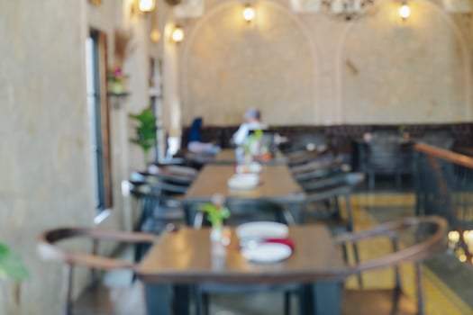 Interior portrait of a restaurant with a lot of tables and chairs. photo