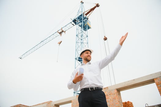 Architect at a construction site with blueprints photo