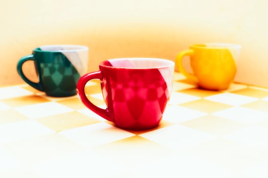 Red green yellow cups on chess board.Tea time,coffee break photo