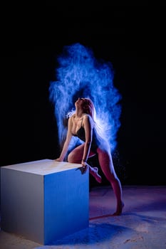 Young woman posing with blue particles in the air photo