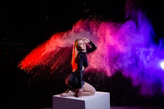 Young woman posing with multicolored particles in the air photo