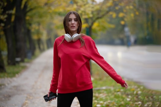 Athletic young woman taking a breath and relaxing after jogging and stretching. Woman Training and Workout Exercises On Street. photo