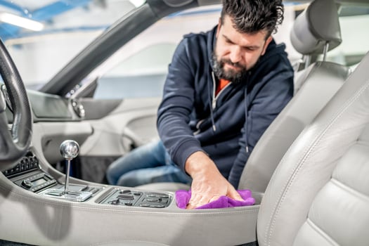 manual detailing and polishing of luxury car interiors with a microfiber photo