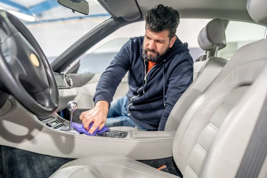 manual cleaning and polishing of luxury car interiors with a microfiber photo