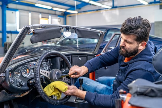 cleaning the interior of the old car with a brush and rag photo