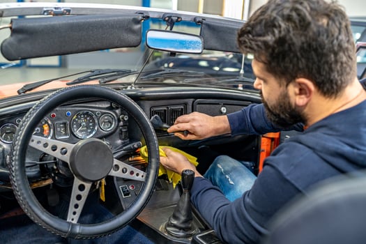 cleaning the interior of the old car with a brush and rag photo