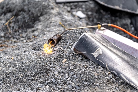 flame of fire from a gas burner to heat asphalt belts for building insulation photo