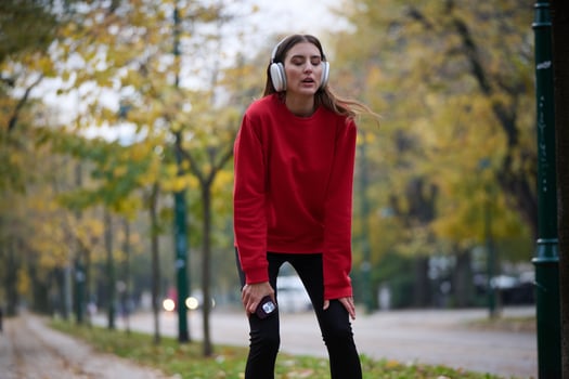 Athletic young woman taking a breath and relaxing after jogging and stretching. Woman Training and Workout Exercises On Street. photo