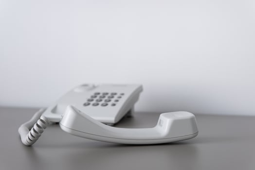 Modern white landline office phone with a hook. Technical support concept. No answer. Closeup white phone , office phone on the desk. Closeup white phone , office phone on the desk. photo