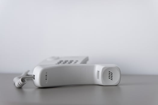 Modern white landline office phone with a hook. Technical support concept. No answer. Closeup white phone , office phone on the desk. Closeup white phone , office phone on the desk. photo
