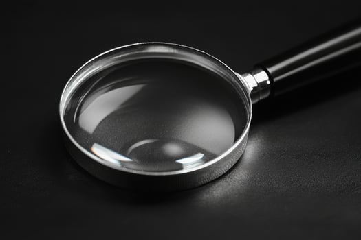 Magnifying glass on black background exploring the unknown photo