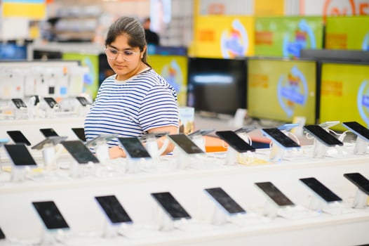 Indian Woman choosing phone at technology store photo
