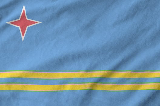 Aruba flag depicted on folded wavy fabric of old cloth photo