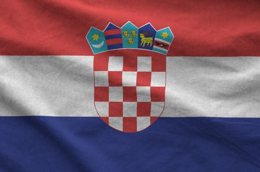 Croatia flag depicted on folded wavy fabric of old cloth photo