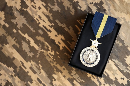 KYIV, UKRAINE - JULY 10, 2024 US Navy Distinguished Service medal. United States military award medal with ribbon and pin. Handmade paper theater props photo