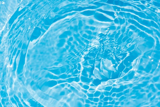 Bluewater waves on the surface ripples blurred. Defocus blurred transparent blue colored clear calm water surface texture with splash and bubbles. Water waves with shining pattern texture background. photo