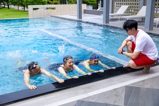Group of senior asian friend is learning how to swim at the swimming pool with professional trainer for retirement exercise workout activities and healthy wellbeing photo
