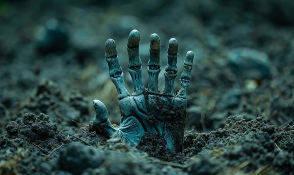 A skeleton hand emerging from the ground in a dark cemetery, with open space at the top for a message photo