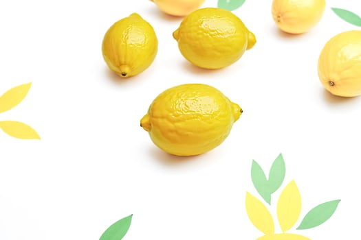 Fresh Lemons and Green Leaves on a White Background photo