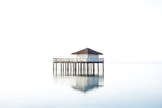 Minimalist Overwater Bungalow Reflecting in Calm Waters photo