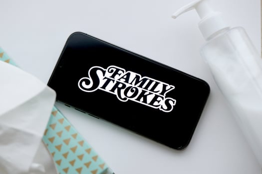KYIV, UKRAINE - JANUARY 23, 2024 FamilyStrokes adult content website logo on display of iPhone 12 Pro photo
