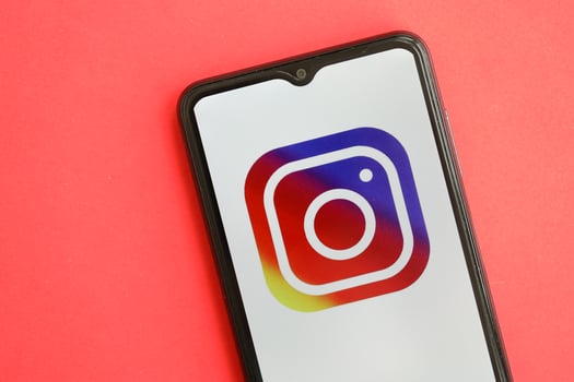 KYIV, UKRAINE - APRIL 1, 2024 Instagram icon on smartphone screen on red table photo