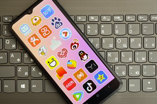 KYIV, UKRAINE - APRIL 1, 2024 Asian apps icon on smartphone screen on black keyboard photo