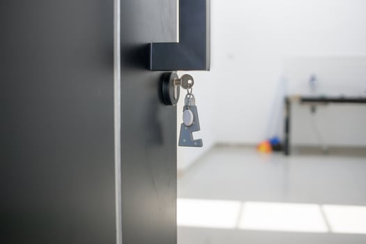 A house key with a key ring inserted at the door lock. Buy new home or concept photo