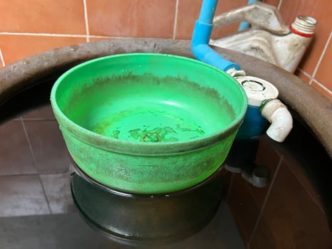 a closeup shot of a dirty green plastic bowl on water tank photo
