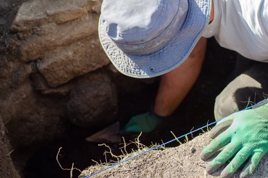 an unrecognizable archaeologist digging with a trowel, concept of archaeology photo