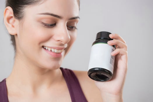 Cute Female Model Lovingly Looking At The Medicine Bottle photo