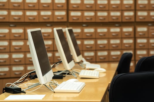 computer terminals in a modern library with blurred catalog cabinets in the background photo