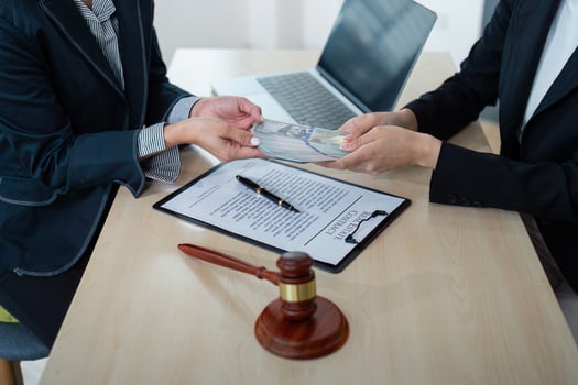Lawyer Accepting Bribe Money in Office. Corruption and Bribery Concept with Legal Documents and Gavel photo