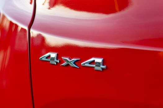 Grunge track 4x4 letters. The designation of all-wheel drive on SUVs. Unique off-road inscription in silver on a red back. photo