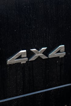 Grunge track 4x4 letters. The designation of all-wheel drive on SUVs. Unique off-road inscription in silver on a black back. photo
