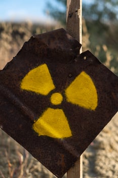 Radiation sign on a rusty metal plate. Hazard warning. Post-apocalyptic sign. photo