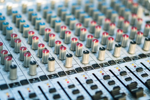 Close-up of the handles and sliders of an audio mixer. Blurred back. photo