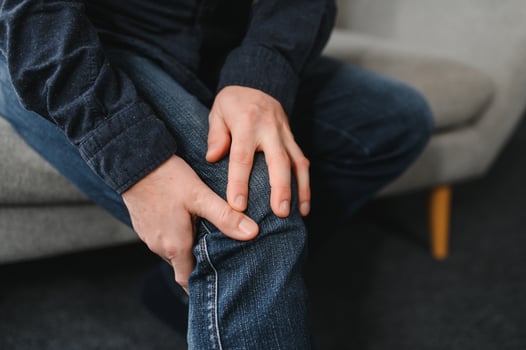 people, health care and problem concept - unhappy senior man suffering from knee ache at home photo
