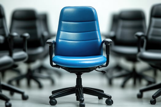 Blue office chair standing out from the crowd of black office chairs photo