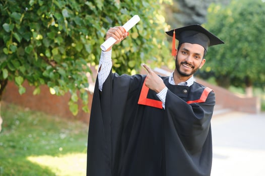 portrait of successful indian student in graduation gown. photo