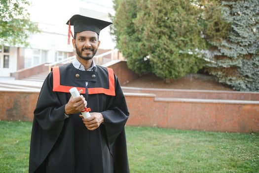 Portrait of indian handsome male graduate in graduation robe. photo