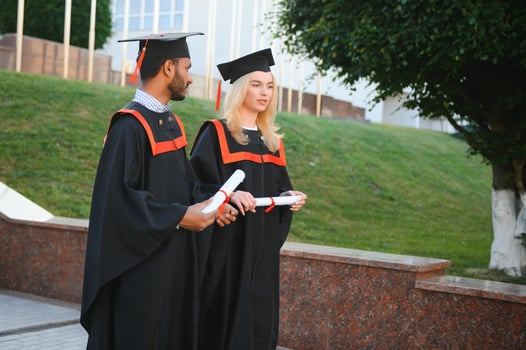 a multiracial group of graduates. Indian male graduate and European female student happy with diplomas in hands. photo