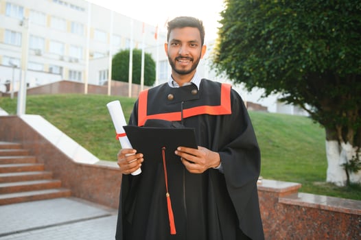 Handsome indian graduate in graduation glow with diploma. photo