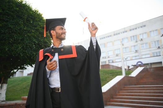 Portrait of indian handsome male graduate in graduation robe. photo