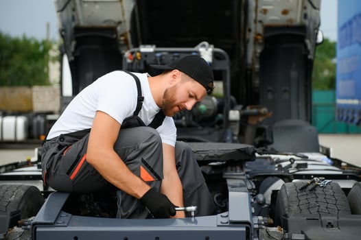 Professional truck mechanic working in vehicle repair service. photo
