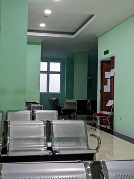 Empty hospital waiting room with chairs and green walls. photo