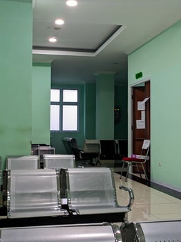 Empty hospital waiting room with chairs and green walls. photo