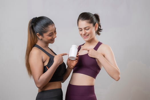 Two Attractive Females Pointing Their Fingers At The Tablet Bottle photo